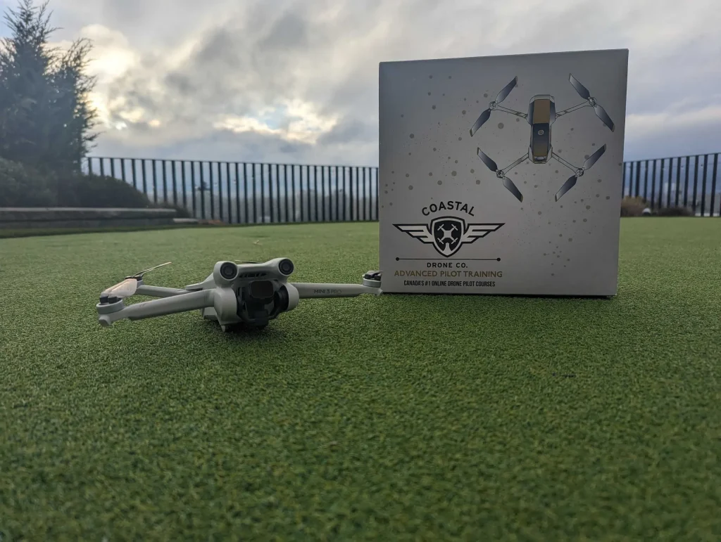DJI Mini 3 Pro on artificial turf beside a Coastal Drone Co. Advanced Pilot Training course box